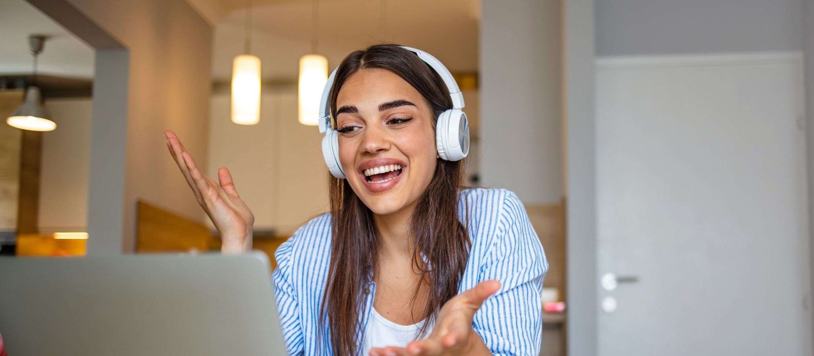 A girl joining online language programs through her laptop and wearing headphone