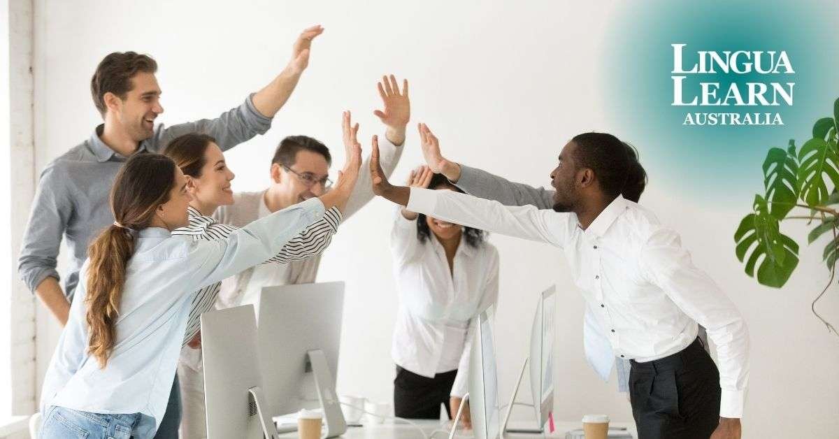 A group of people giving high-fives with the team after achieving Superior English results